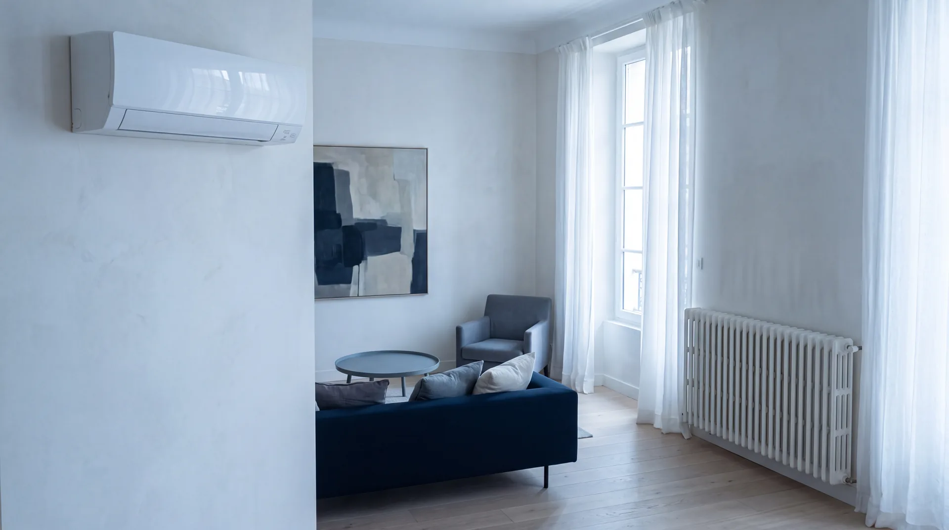 Séjour équipé à la fois d'une unité murale de climatisation et d'un radiateur classique.