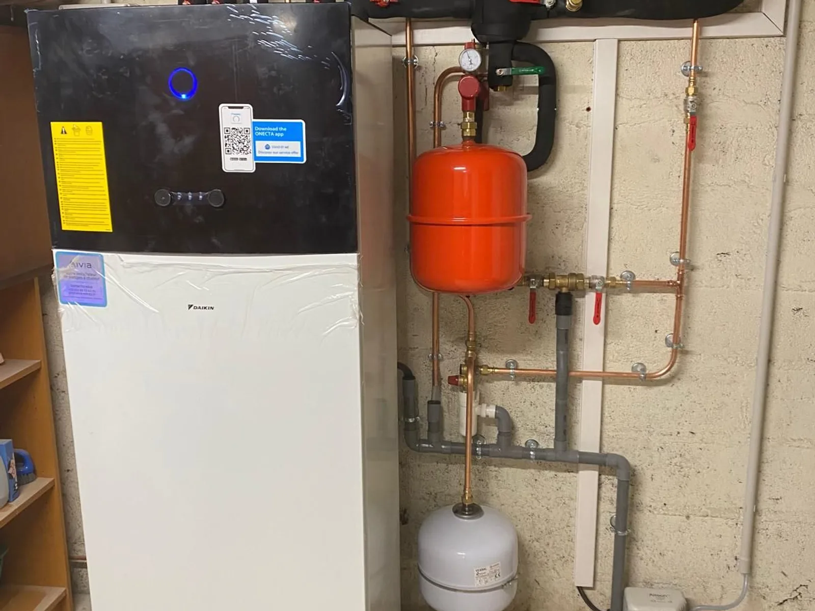 Module intérieur d'une pompe à chaleur air/eau installée par Climprotech, avec vase d'expansion et raccordements hydrauliques.