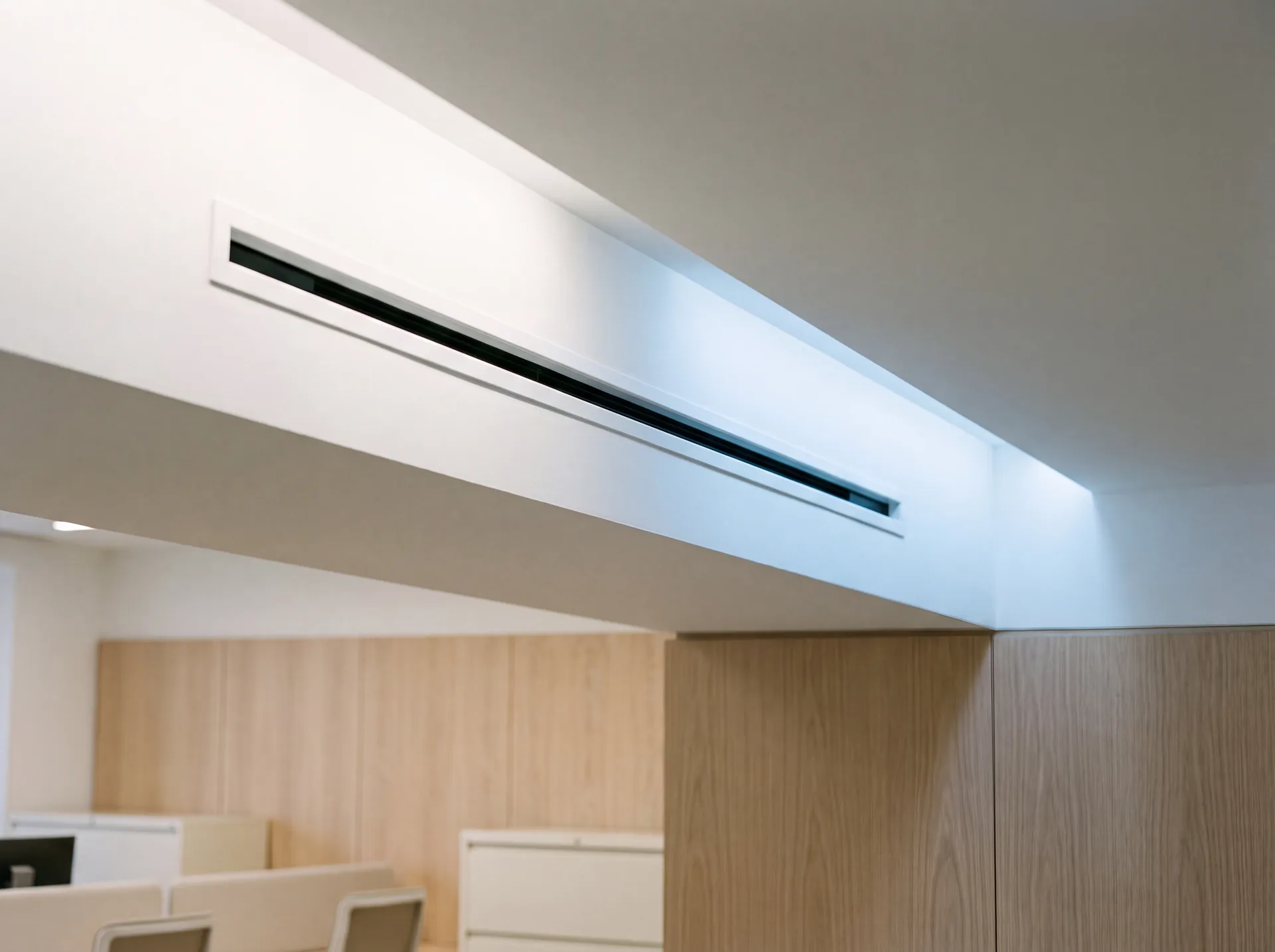 Grille de soufflage linéaire intégrée au plafond, seule partie visible d'un système gainable.